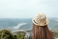 Woman traveler with a hat standing on a background of green mountains Royalty Free Stock Photo