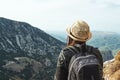 Woman traveler with a hat standing on a background of green mountains Royalty Free Stock Photo