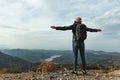 Woman traveler with a hat standing on a background of green mountains Royalty Free Stock Photo