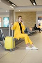 Woman traveler looking at smartphone waiting her airport flight check-in