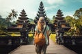 Woman traveler at Pura Besakih temple in Bali, Indonesia, Tourist woman with backpack at vacation walking through the Hindu temple
