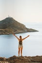 Woman traveler raised hands enjoying sea and lighthouse view travel healthy lifestyle active summer vacations outdoor Royalty Free Stock Photo