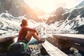 Woman traveler rests near mountain lake with beautiful view on s Royalty Free Stock Photo