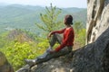 Woman traveler sits and looks at the valley