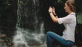Woman traveler stand near waterfall at rainforest