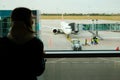 Woman traveler standing near panoramic big window at airport. Lady waiting for flight. Travel, journey, airplane concept Royalty Free Stock Photo