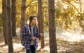 Woman traveler in sunny forest alone. Backpacker girl enjoying walking outdoors