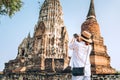 Woman traveler takes a phoot of atcient Wat Chaiwatthanaram Buddhist temple in the city of Ayutthaya Historical Park, Thailand