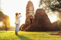 Woman traveler takes a photo of atcient Wat Chaiwatthanaram Buddhist temple in holy city Ayutthaya, Thailand