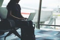 A woman traveler using laptop computer in the airport Royalty Free Stock Photo