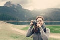 Woman traveler with vintage camera taking a photo, nature landscape Royalty Free Stock Photo