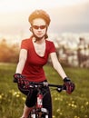 Woman traveling bicycle in summer park.