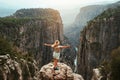 Woman traveling in mountains of Turkey standing on cliff raised hands Royalty Free Stock Photo