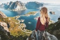 Woman traveling in Norway standing on cliff of Reinebringen mountain aerial view