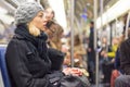 Woman traveling by subway full of people.