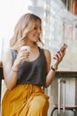 Woman traveling with a suitcase drinking coffee and looking at h Royalty Free Stock Photo