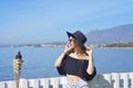 Woman traveling talking on the phone, cute girl smile, on background of the sea / ocean. The concept of connection and communicati Royalty Free Stock Photo