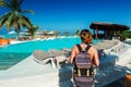 Woman traveller with backpack near swimming pool at tropical island Royalty Free Stock Photo