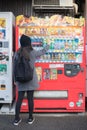 Woman traveller buying a drink from vending machine.