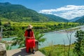 Woman traveller enjoying the spectacular view of blue mountains and Tsang river on a sunny day from the suspension bridge linking