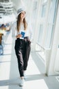 woman traveller holding passport waiting in transit area of airport, stand by for the next schedule traveling, late Royalty Free Stock Photo