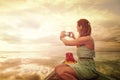 Woman traveller photographing on smartphone a sunset, enjoying c