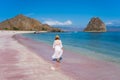 A woman traveller walking on pink beach in Komodo national park, Flores island, Indonesia
