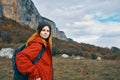 woman travels in the mountains with a backpack on her back landscape autumn warm clothes model