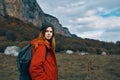 woman travels in the mountains with a backpack on her back landscape autumn warm clothes model