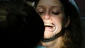 Woman is treating teeth with an orthodontic fixator in her mouth close up. Visit to the dentist