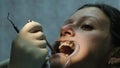 Woman is treating teeth with an orthodontic fixator in her mouth close up. Visit to the dentist