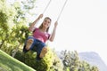 Woman on tree swing smiling