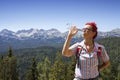 Woman trekker drinks high in the mountains