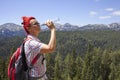 Woman trekker drinks high in the mountains