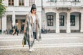 Woman in trend multilayered outfit walks in autumn city street. Royalty Free Stock Photo