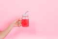 Woman with trendy turquoise manicure holds a transparent glass with tasty bright soda for birthday party. Girl showing