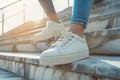 Woman in trendy white sneakers ascending concrete stairs Royalty Free Stock Photo