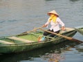 Woman in triangular hat in a paddle boat in Vietnam