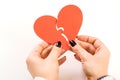 Woman tries to connect two parts of a paper broken heart, top view. Valentine`s day. Love, relationship, divorce Royalty Free Stock Photo