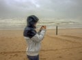 Woman tries to take a picture during a severe tempest hits the coast near Noordwijk town