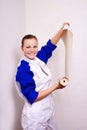 Woman tries on wall-papers to wall Royalty Free Stock Photo