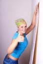 Woman tries on wall-papers to wall Royalty Free Stock Photo