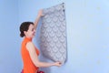 Woman tries on wall-papers to wall