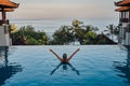 Woman on trip in bali enjoying swimming pool