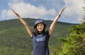 Triumphant woman hiker on top of a mountain summit