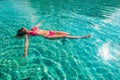 woman in red bikini floating on deep swimming pool Royalty Free Stock Photo
