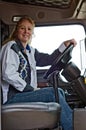 Woman truck driver looking across the truck through an open door. Royalty Free Stock Photo