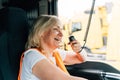 Woman truck driver talking by radio inside the cabin. Female trucker job worker Royalty Free Stock Photo