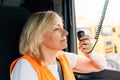 Woman truck driver talking by radio inside the cabin. Female trucker job worker Royalty Free Stock Photo