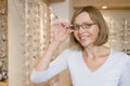 Woman trying on eyeglasses at optometrists